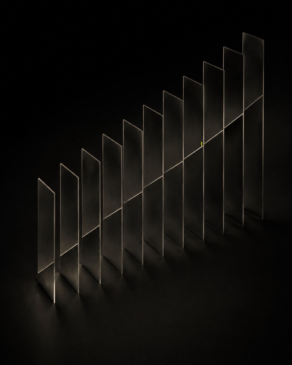 A stepped diagonal array of thin smoked-glass planes on an almost black field, located by one fine bone line and a small lime tick.
